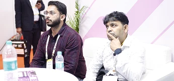 Partners standing beside COLTEC panel discussing deployment plans