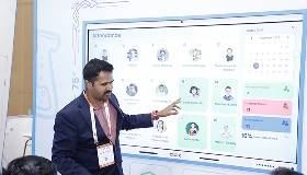 Presenter explaining Qeeb dashboard on COLTEC panel to attendees